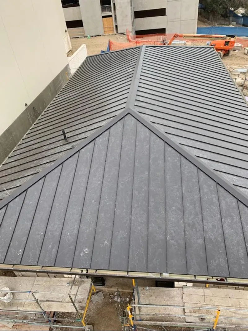 Commercial metal roof construction with crane equipment in Westbrook